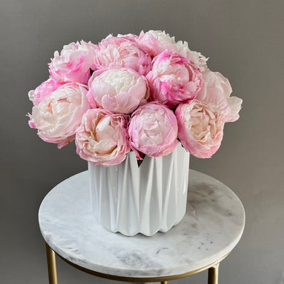 Pink-white peonies in white vase